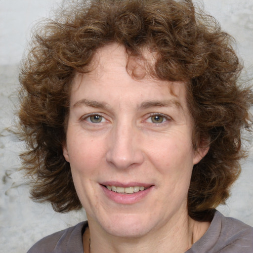 Joyful white adult female with medium  brown hair and blue eyes