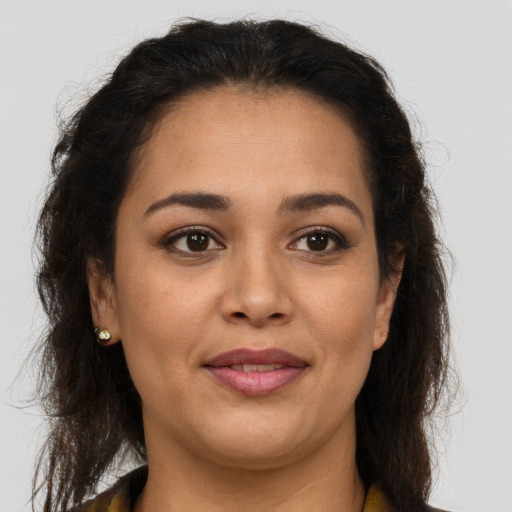 Joyful latino adult female with long  brown hair and brown eyes