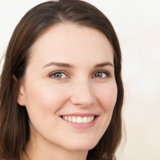 Joyful white young-adult female with long  brown hair and brown eyes