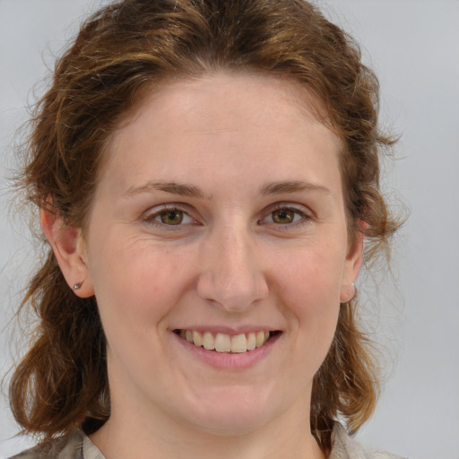 Joyful white young-adult female with medium  brown hair and blue eyes