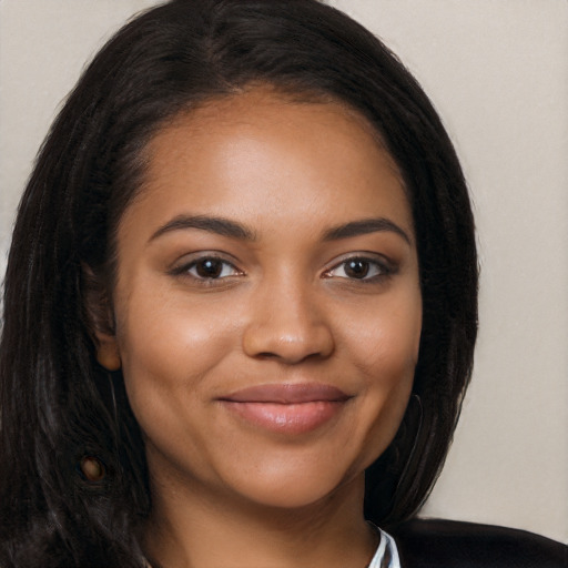 Joyful black young-adult female with long  black hair and brown eyes