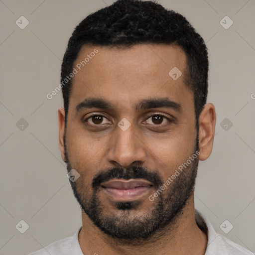 Joyful black young-adult male with short  black hair and brown eyes