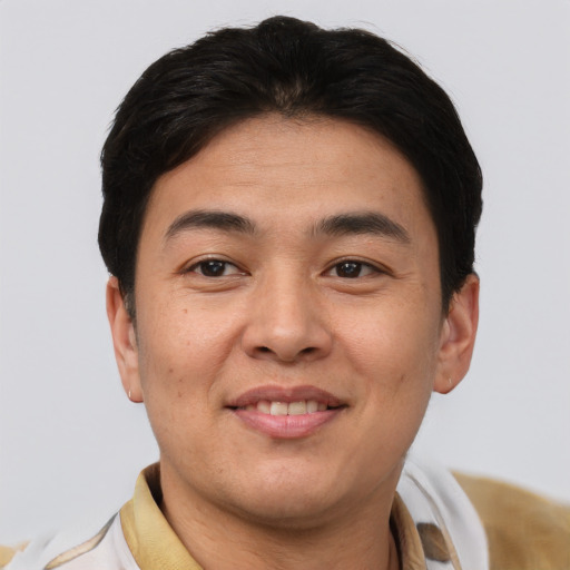 Joyful asian young-adult male with short  brown hair and brown eyes