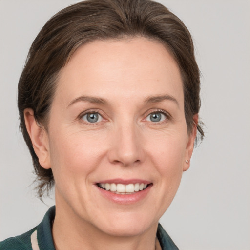 Joyful white adult female with medium  brown hair and grey eyes