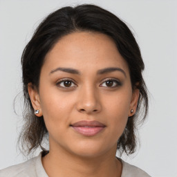 Joyful latino young-adult female with medium  brown hair and brown eyes