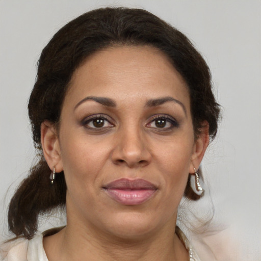 Joyful latino adult female with medium  brown hair and brown eyes