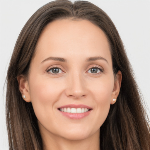 Joyful white young-adult female with long  brown hair and grey eyes