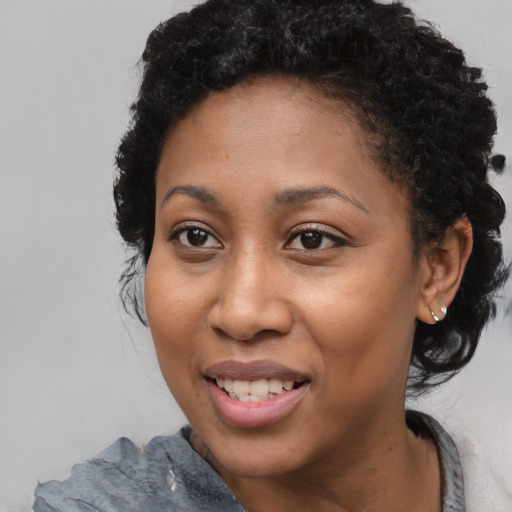Joyful black adult female with short  black hair and brown eyes