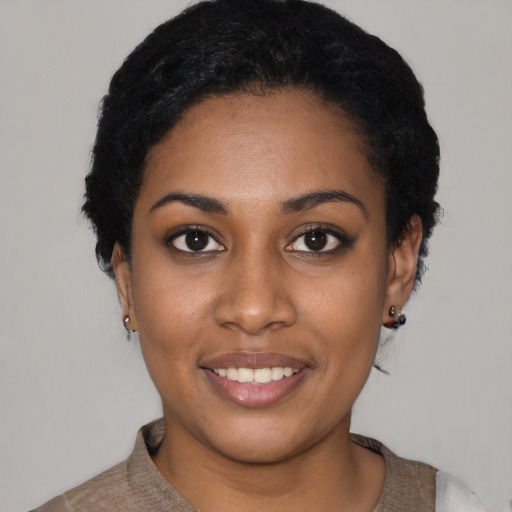 Joyful black young-adult female with short  black hair and brown eyes