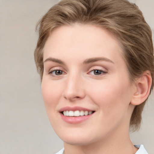 Joyful white young-adult female with medium  brown hair and grey eyes