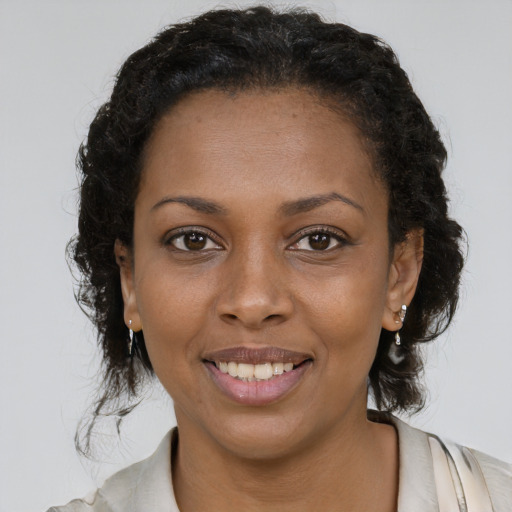 Joyful black young-adult female with long  brown hair and brown eyes