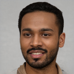 Joyful black young-adult male with short  black hair and brown eyes