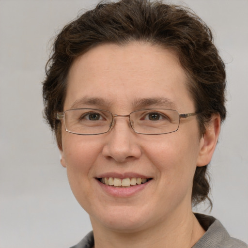 Joyful white adult female with medium  brown hair and green eyes