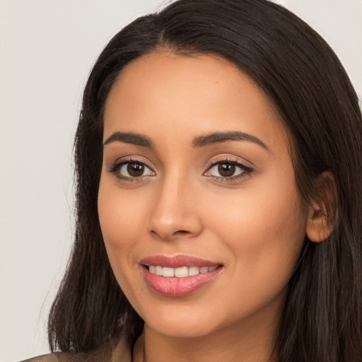 Joyful latino young-adult female with long  brown hair and brown eyes