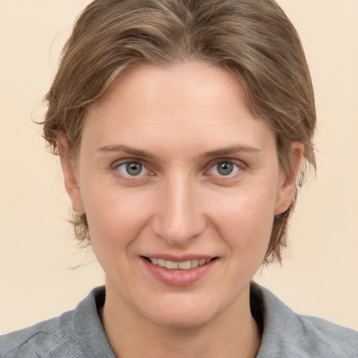 Joyful white young-adult female with medium  brown hair and grey eyes