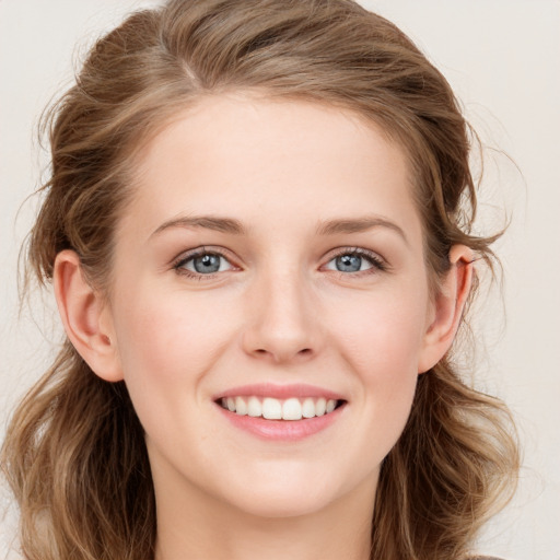 Joyful white young-adult female with long  brown hair and blue eyes