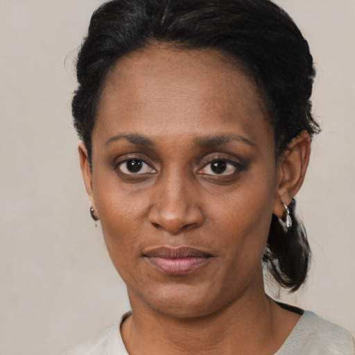 Joyful black adult female with short  black hair and brown eyes