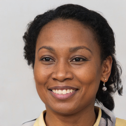 Joyful black adult female with long  brown hair and brown eyes