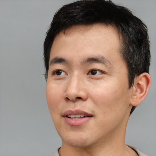Joyful asian young-adult male with short  brown hair and brown eyes