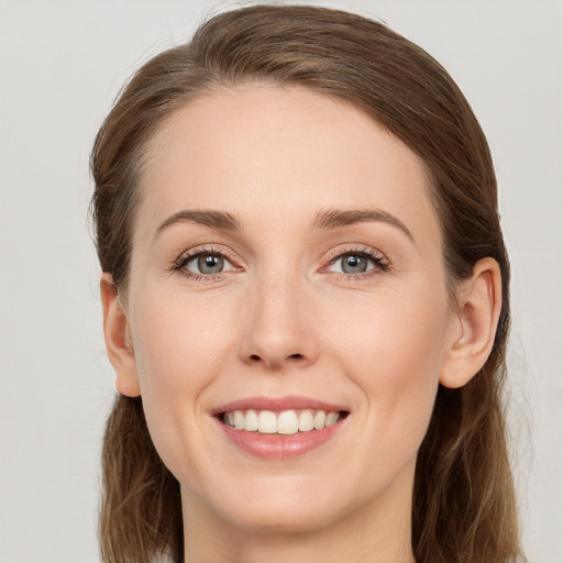 Joyful white young-adult female with medium  brown hair and green eyes