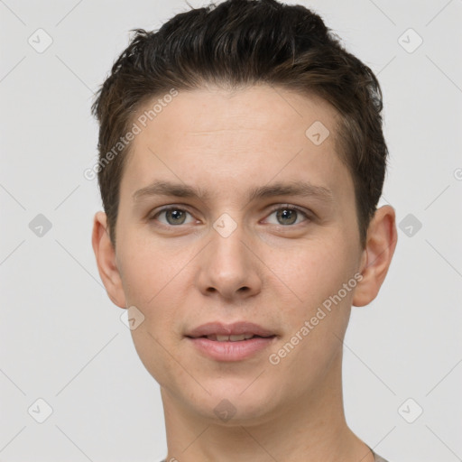 Joyful white young-adult male with short  brown hair and grey eyes