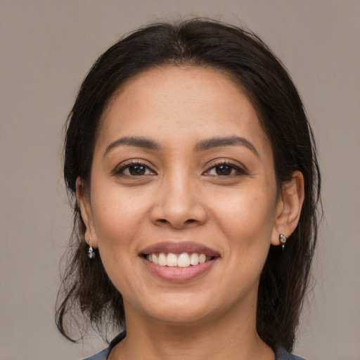 Joyful latino young-adult female with medium  brown hair and brown eyes