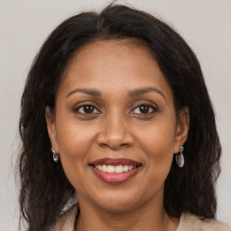 Joyful black adult female with long  brown hair and brown eyes