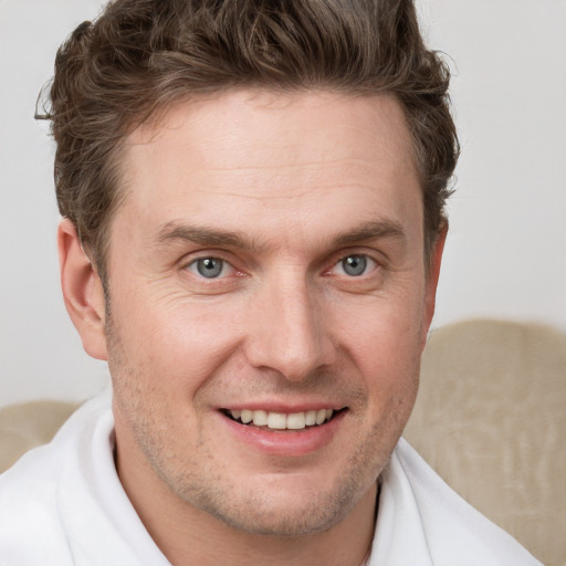 Joyful white adult male with short  brown hair and grey eyes