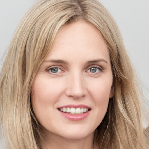 Joyful white young-adult female with long  brown hair and blue eyes