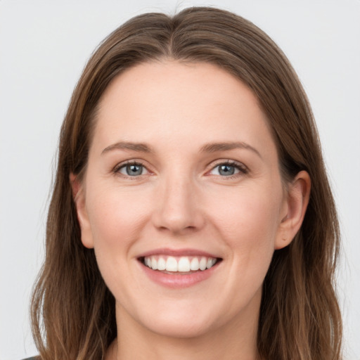 Joyful white young-adult female with long  brown hair and grey eyes