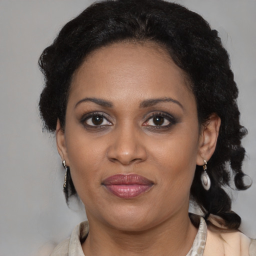 Joyful black adult female with medium  brown hair and brown eyes