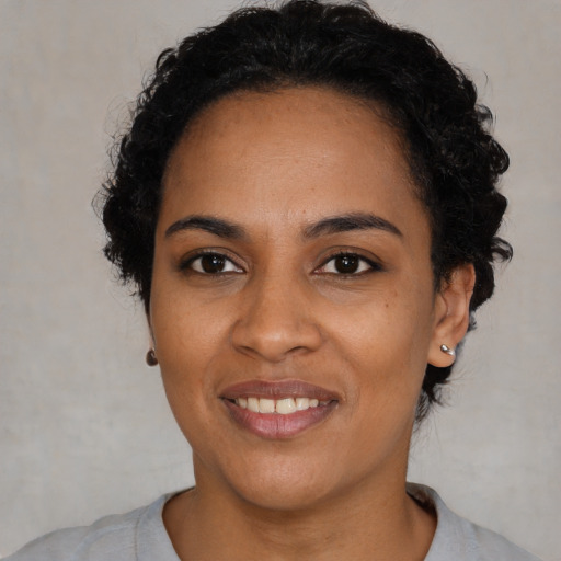 Joyful black young-adult female with medium  black hair and brown eyes