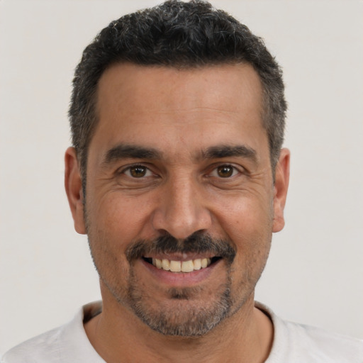 Joyful white adult male with short  black hair and brown eyes
