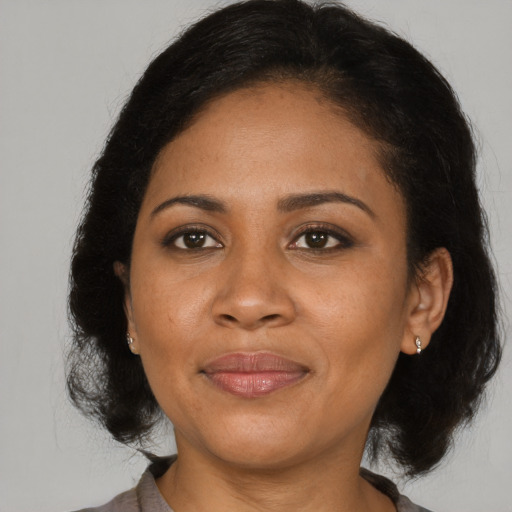 Joyful black adult female with medium  brown hair and brown eyes
