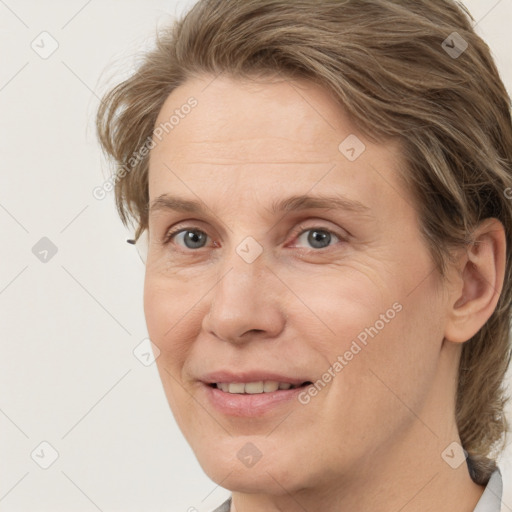 Joyful white adult female with medium  brown hair and grey eyes