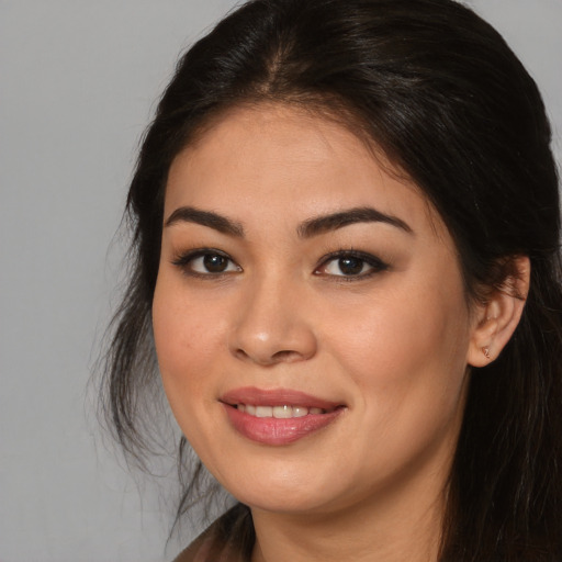 Joyful asian young-adult female with long  brown hair and brown eyes