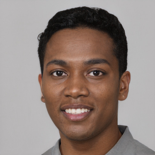 Joyful black young-adult male with short  black hair and brown eyes