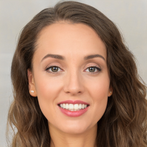 Joyful white young-adult female with long  brown hair and brown eyes