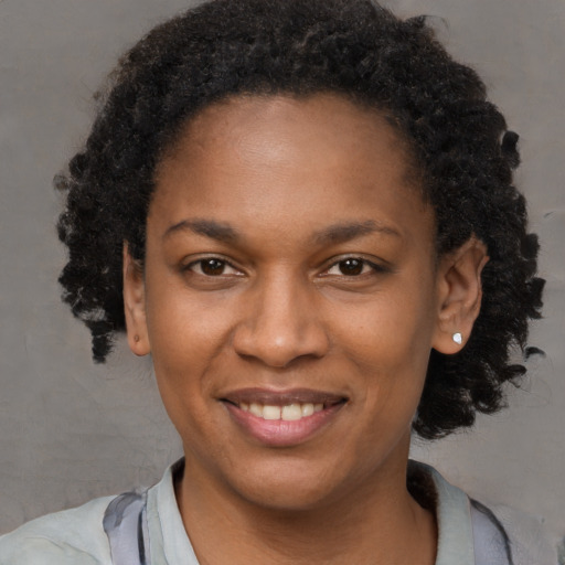 Joyful black young-adult female with medium  brown hair and brown eyes