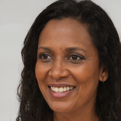 Joyful black adult female with long  brown hair and brown eyes
