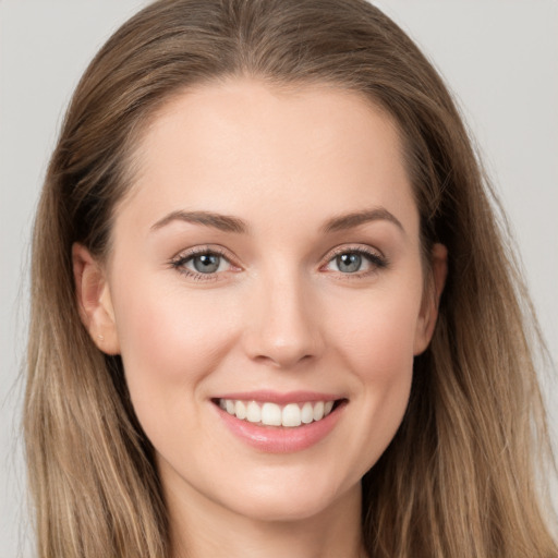 Joyful white young-adult female with long  brown hair and grey eyes