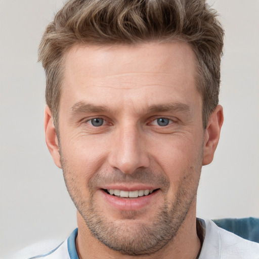 Joyful white adult male with short  brown hair and grey eyes