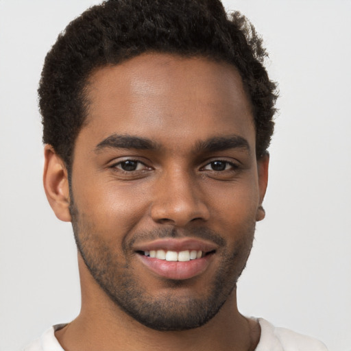 Joyful black young-adult male with short  brown hair and brown eyes