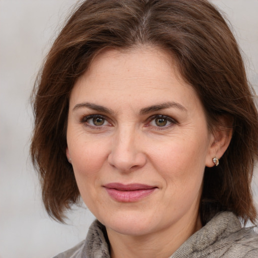 Joyful white adult female with medium  brown hair and brown eyes