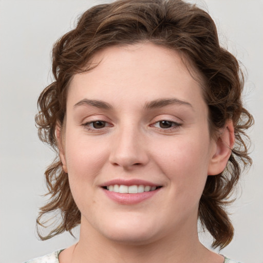 Joyful white young-adult female with medium  brown hair and blue eyes