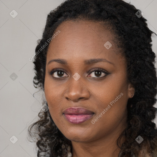 Joyful black young-adult female with long  black hair and brown eyes