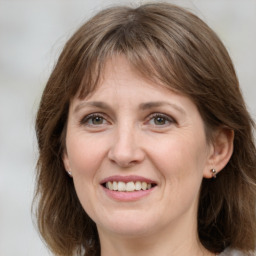 Joyful white adult female with medium  brown hair and grey eyes