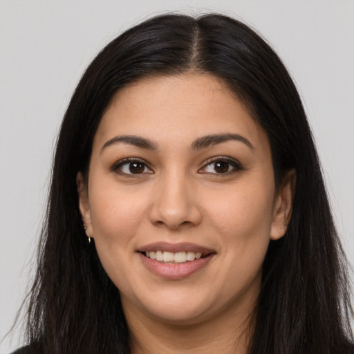 Joyful latino young-adult female with long  brown hair and brown eyes