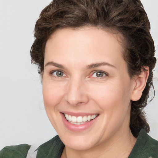 Joyful white young-adult female with medium  brown hair and green eyes