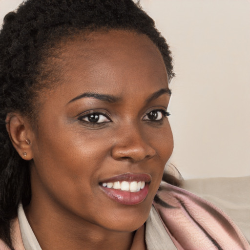 Joyful black young-adult female with long  brown hair and brown eyes